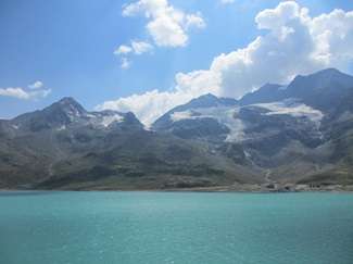 Lago alpino sovrastato dalla mole innevata del Monte Bernina